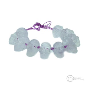 Faceted Quartz bracelet with 12 mini human skulls on a purple string